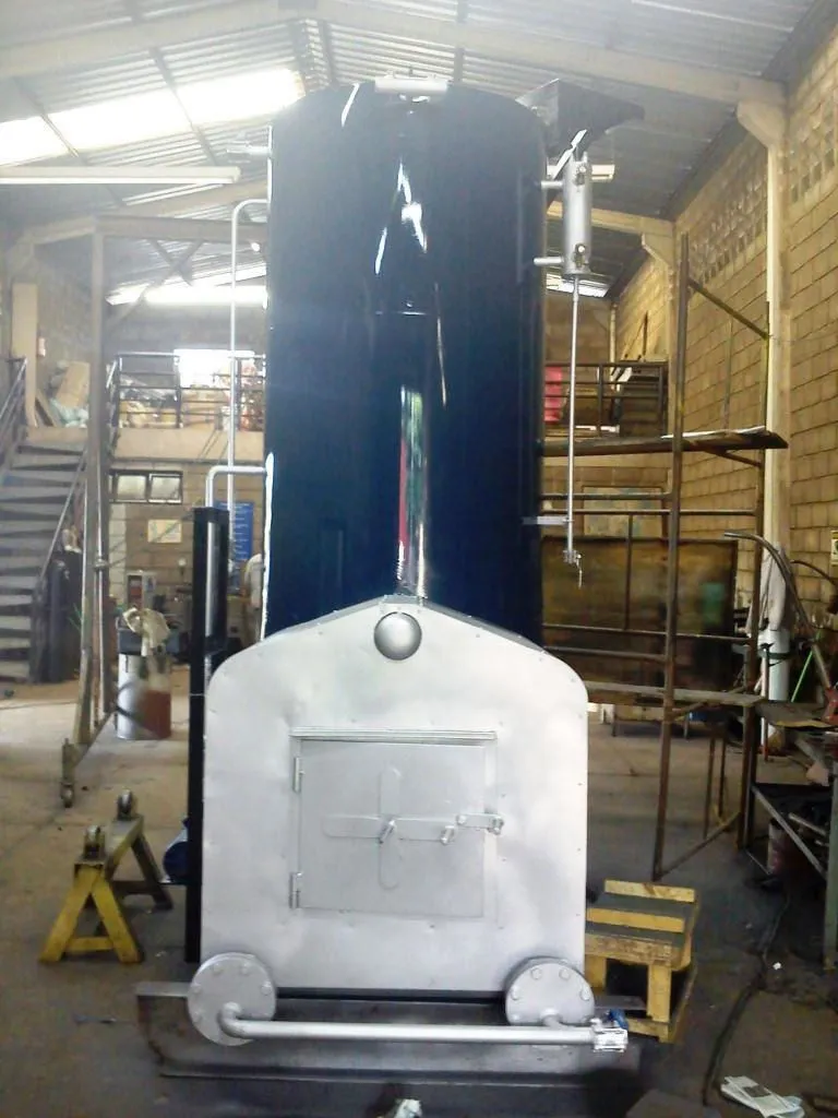 Caldeira industrial vertical com fornalha em fabricação dentro de oficina, vista frontal