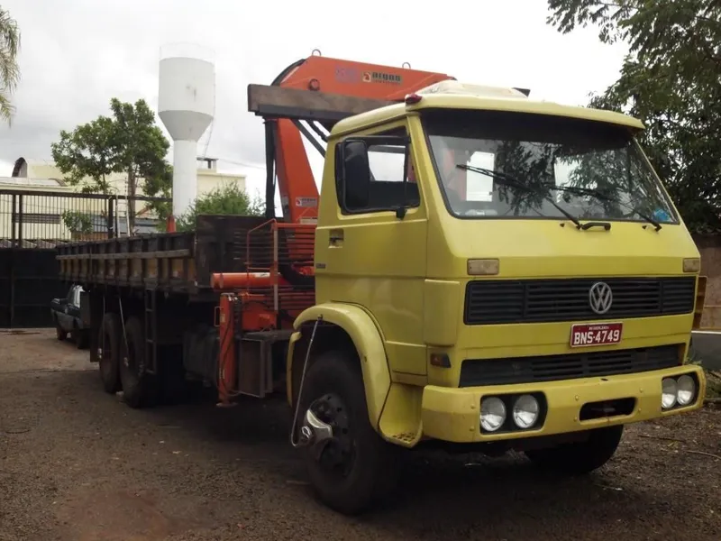 Caminhão munck posicionando carga em obra industrial