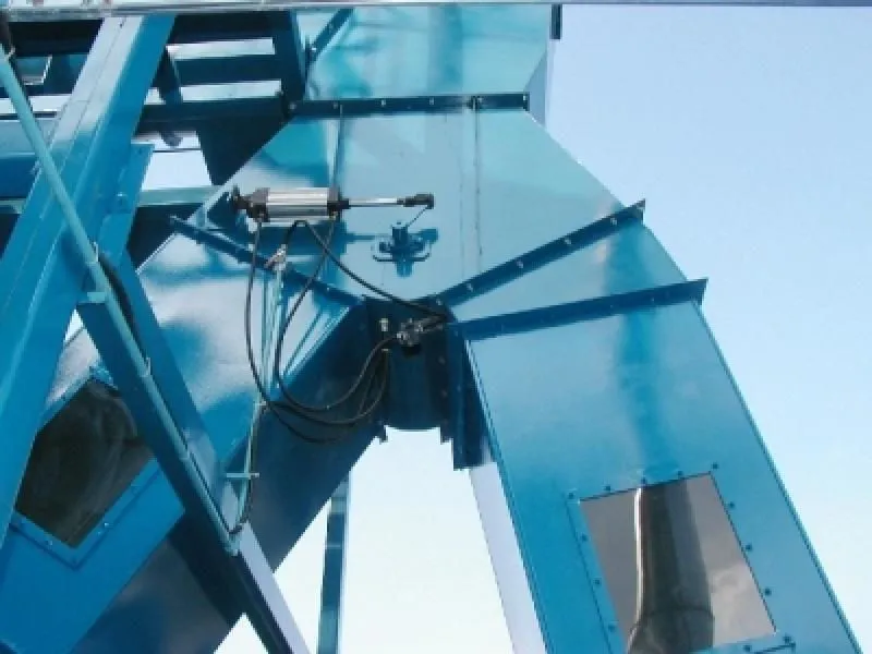 Detalhe de dutos metálicos azuis com cilindro pneumático em equipamento industrial de processo