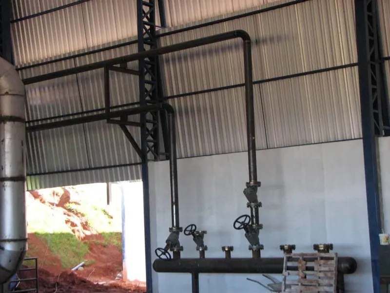 Coletor de vapor com válvulas e tubulações instalado dentro de galpão industrial